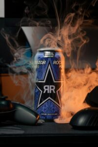 A vibrant energy drink can enveloped in swirling vape smoke, creating an edgy atmosphere.
